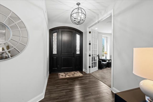 8353 Pier Point Ct, South Lyon, MI 48178 - foyer entrance featuring a chandelier, baseboards, and wood finished floors