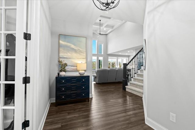 8353 Pier Point Ct, South Lyon, MI 48178 - entrance foyer featuring wood finished floors, stairs, baseboards, a chandelier, and beamed ceiling