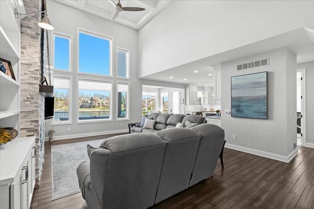 8353 Pier Point Ct, South Lyon, MI 48178 - living room featuring dark wood-style flooring, ceiling fan, baseboards, a high ceiling, and beamed ceiling