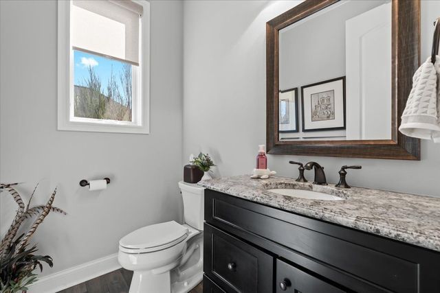 8353 Pier Point Ct, South Lyon, MI 48178 - half bathroom with toilet, vanity, wood finished floors, and baseboards