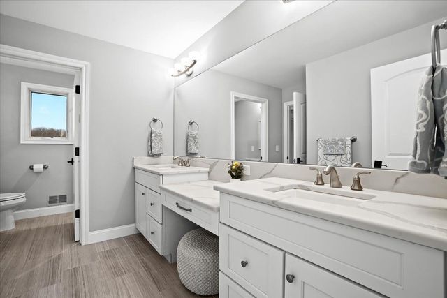 8353 Pier Point Ct, South Lyon, MI 48178 - bathroom featuring toilet, vanity, baseboards, and wood finished floors