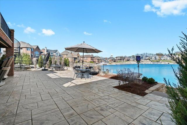 8353 Pier Point Ct, South Lyon, MI 48178 - view of patio with a residential view, outdoor dining space, a water view, and fence