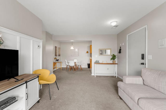 living area with light carpet and baseboards