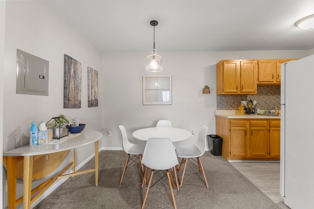 dining room with electric panel and baseboards