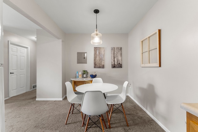 carpeted dining space featuring electric panel and baseboards