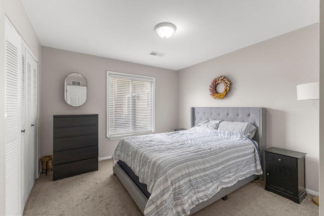 bedroom featuring light carpet, baseboards, and a closet