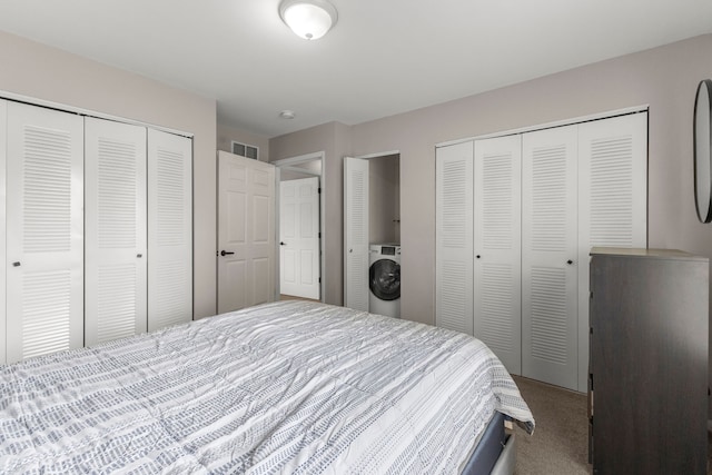 bedroom featuring washer / clothes dryer, carpet flooring, and multiple closets