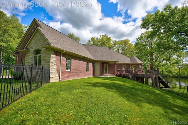 3074 Pond Rd, Leonard, MI 48367 - rear view of house featuring stone siding, roof with shingles, a wooden deck, and brick siding