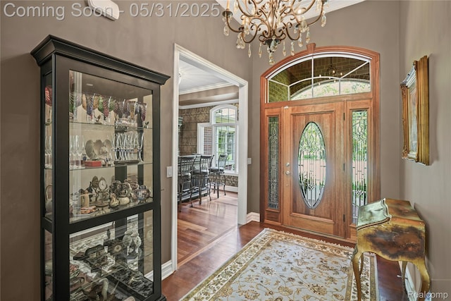 3074 Pond Rd, Leonard, MI 48367 - entrance foyer featuring dark wood-style flooring, a chandelier, baseboards, and ornamental molding