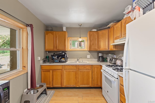 5309 Treat Hwy, Adrian, MI 49221 - kitchen with white appliances, a sink, under cabinet range hood, light countertops, and light wood finished floors