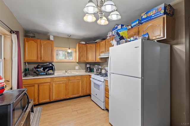 5309 Treat Hwy, Adrian, MI 49221 - kitchen with white appliances, under cabinet range hood, a sink, light countertops, and light wood-style floors