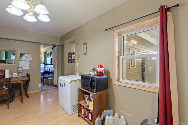 5309 Treat Hwy, Adrian, MI 49221 - laundry room with light wood-style floors and a chandelier