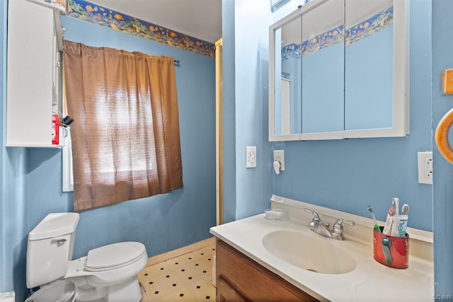 5309 Treat Hwy, Adrian, MI 49221 - bathroom featuring toilet, vanity, and baseboards