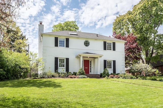 2124 Brockman Blvd, Ann Arbor, MI 48104 - colonial-style house featuring a chimney, a front yard, and brick siding