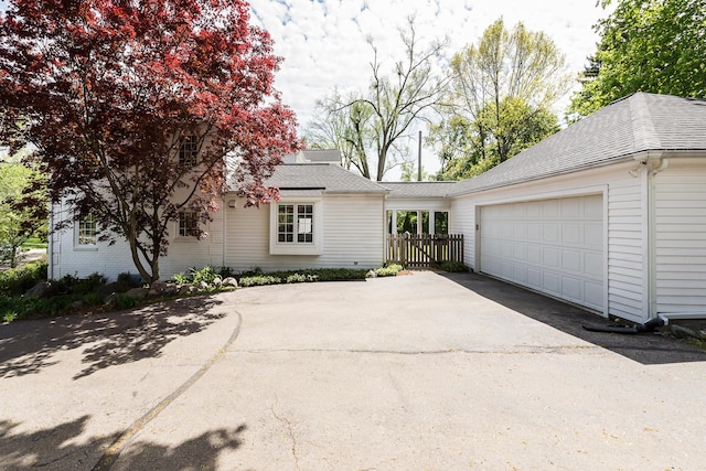 2124 Brockman Blvd, Ann Arbor, MI 48104 - view of front facade featuring asphalt driveway, an attached garage, a shingled roof, and fence