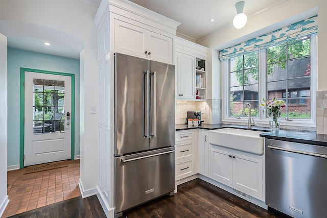 2124 Brockman Blvd, Ann Arbor, MI 48104 - kitchen featuring stainless steel appliances, dark countertops, tasteful backsplash, white cabinetry, and a sink