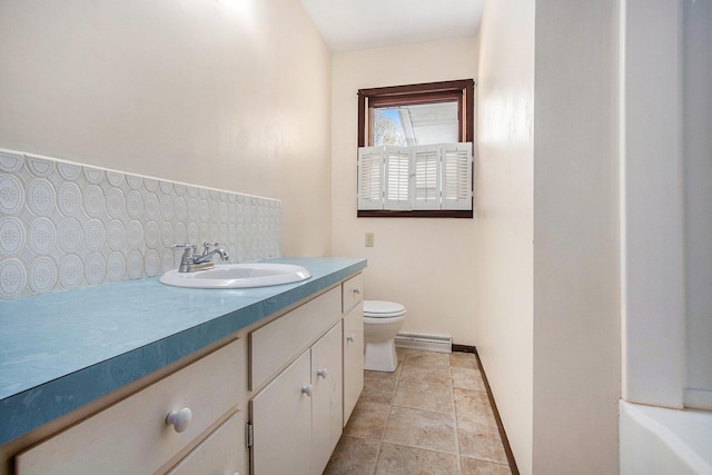 2151 Brown School Rd, Saint Joseph, MI 49085 - bathroom with a baseboard heating unit, decorative backsplash, toilet, vanity, and baseboards