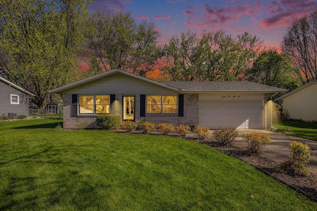 2151 Brown School Rd, Saint Joseph, MI 49085 - view of front of home featuring brick siding, concrete driveway, a garage, and a lawn