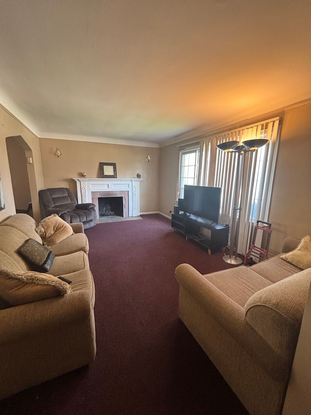 living area featuring carpet flooring, a tiled fireplace, and baseboards