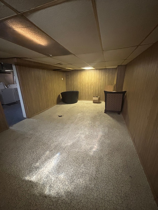 finished basement with wood walls and a paneled ceiling