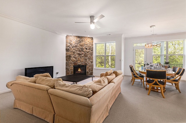 3203 Asher Rd, Ann Arbor, MI 48104 - living room with light colored carpet, a stone fireplace, crown molding, a chandelier, and a ceiling fan