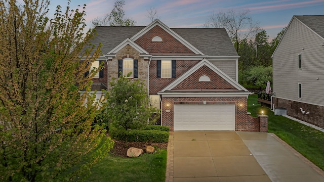 view of front of home with brick siding, concrete driveway, a shingled roof, a garage, and a front lawn