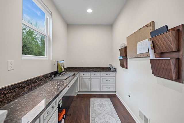 unfurnished office featuring dark wood-type flooring, recessed lighting, and baseboards