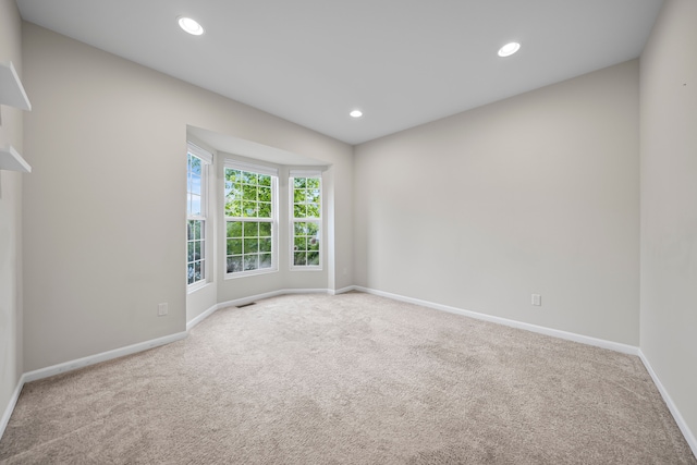 carpeted empty room featuring baseboards and recessed lighting