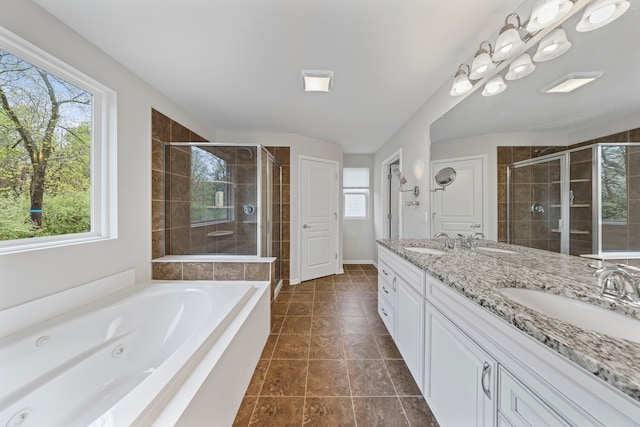 bathroom featuring a stall shower, a whirlpool tub, double vanity, and tile patterned floors
