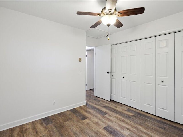 unfurnished bedroom with wood finished floors, baseboards, a closet, and a ceiling fan