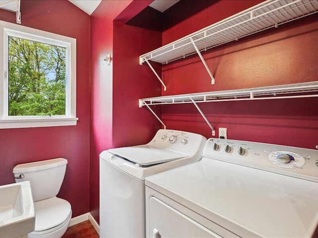 clothes washing area with washing machine and dryer and baseboards