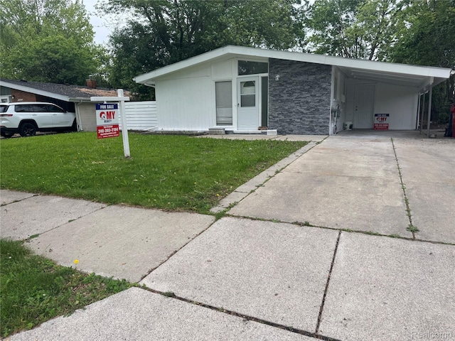 29592 Fairfax St, Southfield, MI 48076 - mid-century modern home with a front lawn, driveway, stone siding, and an attached carport