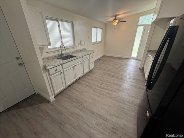 29592 Fairfax St, Southfield, MI 48076 - kitchen with a sink, a ceiling fan, light wood finished floors, white cabinets, and freestanding refrigerator