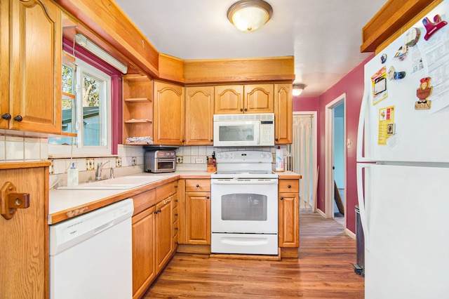 102 Franklin St, Holly, MI 48442 - kitchen featuring white appliances, tasteful backsplash, a sink, light countertops, and light wood-style floors