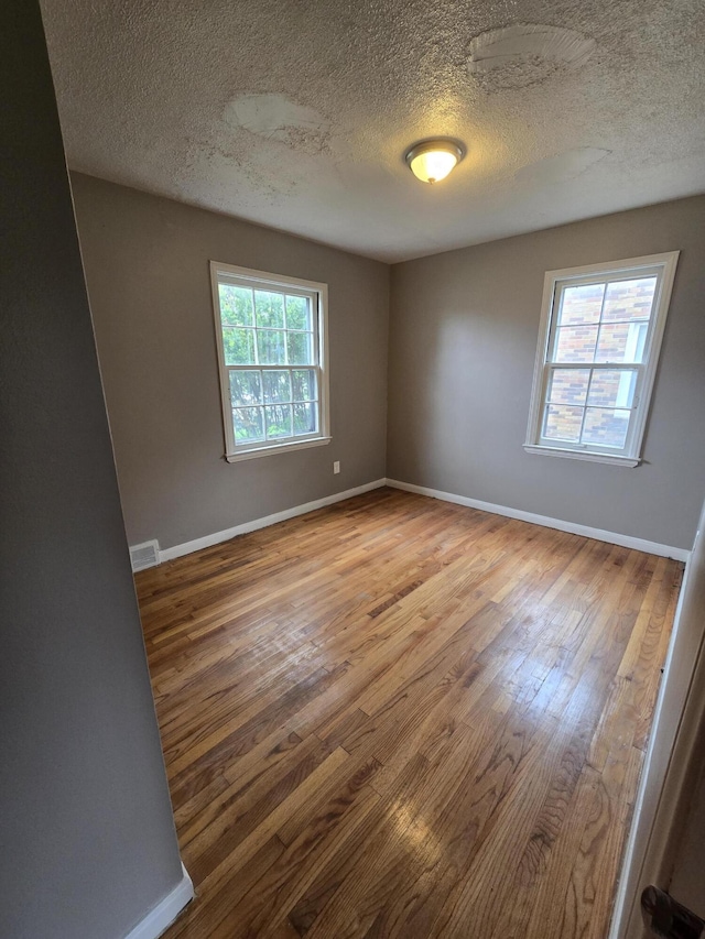 915 Cleophus Pkwy, Lincoln Park, MI 48146 - empty room with a textured ceiling, wood finished floors, and baseboards
