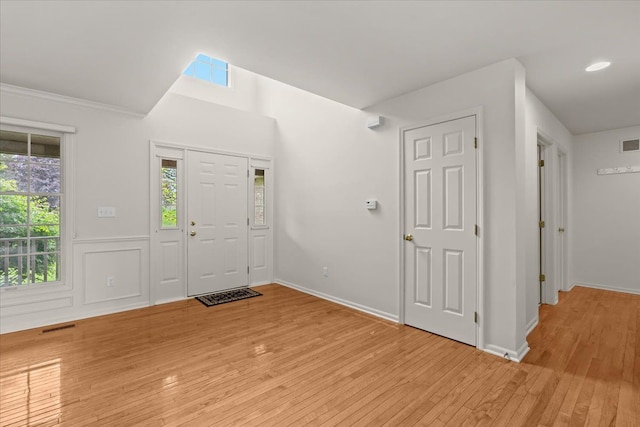 entrance foyer featuring light wood-style floors, baseboards, and ornamental molding