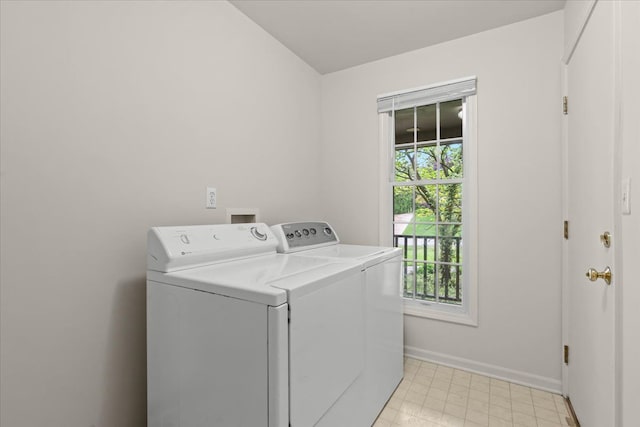 clothes washing area with washing machine and clothes dryer and baseboards