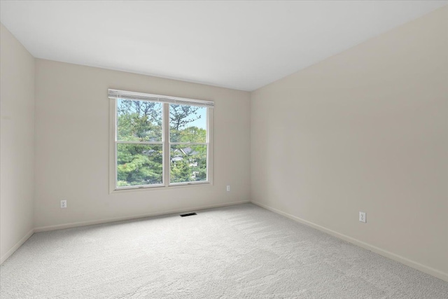 spare room with baseboards and carpet