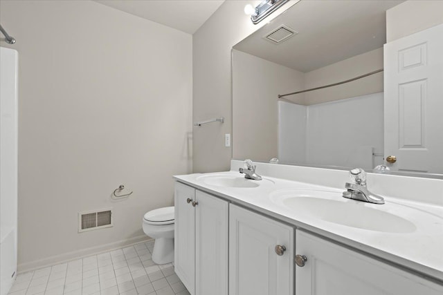 bathroom featuring toilet, a shower, double vanity, and baseboards