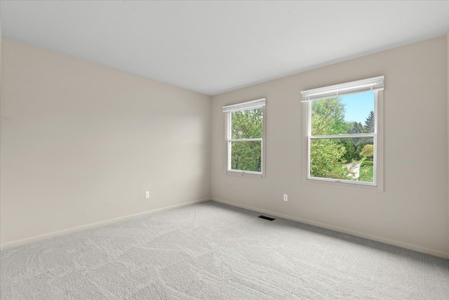 unfurnished room with baseboards and light colored carpet