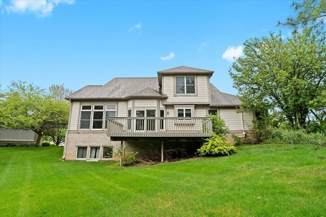 back of house with a lawn, a deck, and a shingled roof