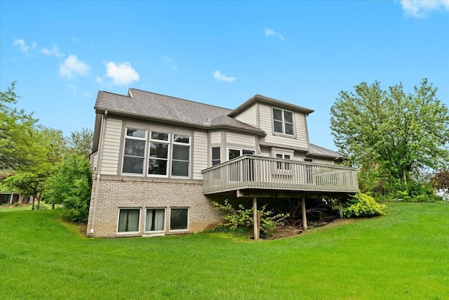 back of house with brick siding, a deck, and a yard