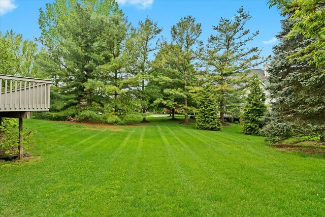 view of grassy yard featuring a wooden deck