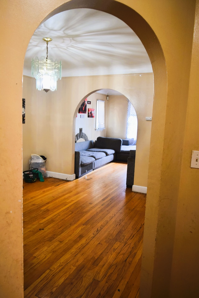 10039 Mark Twain St, Detroit, MI 48227 - hall featuring wood finished floors, baseboards, arched walkways, and a chandelier