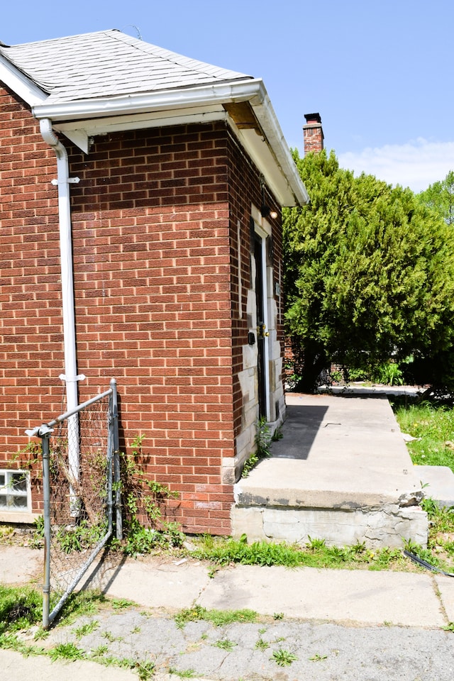 10039 Mark Twain St, Detroit, MI 48227 - view of home's exterior with brick siding, a chimney, and fence