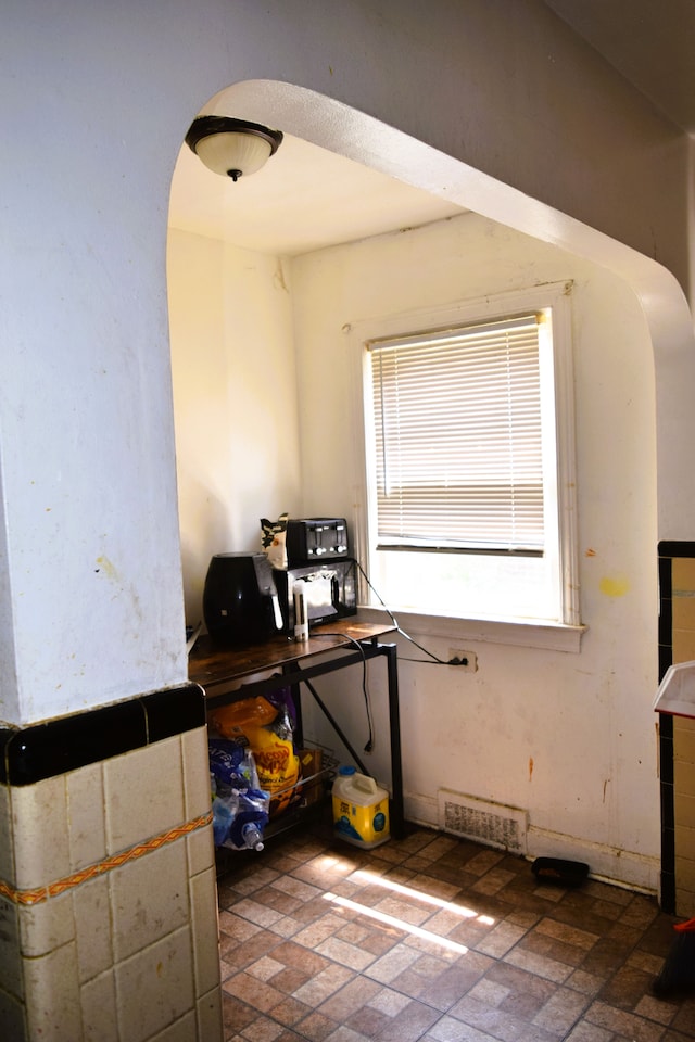 10039 Mark Twain St, Detroit, MI 48227 - interior space featuring arched walkways, brick patterned floors, and plenty of natural light