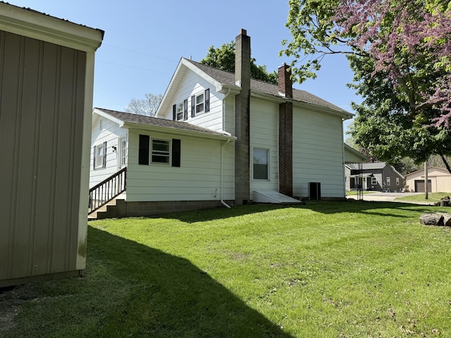 202 Kalamo St, Olivet, MI 49076 - rear view of house featuring a chimney, a yard, and entry steps