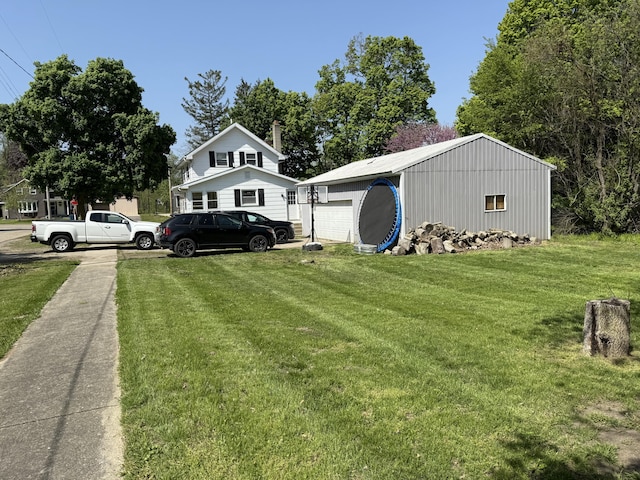 202 Kalamo St, Olivet, MI 49076 - view of green lawn featuring a garage and an outbuilding