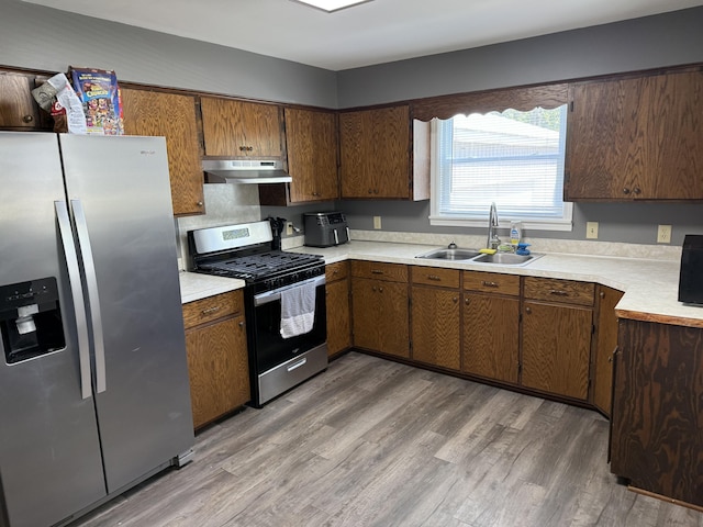 202 Kalamo St, Olivet, MI 49076 - kitchen featuring stainless steel appliances, ventilation hood, a sink, light countertops, and light wood-style flooring