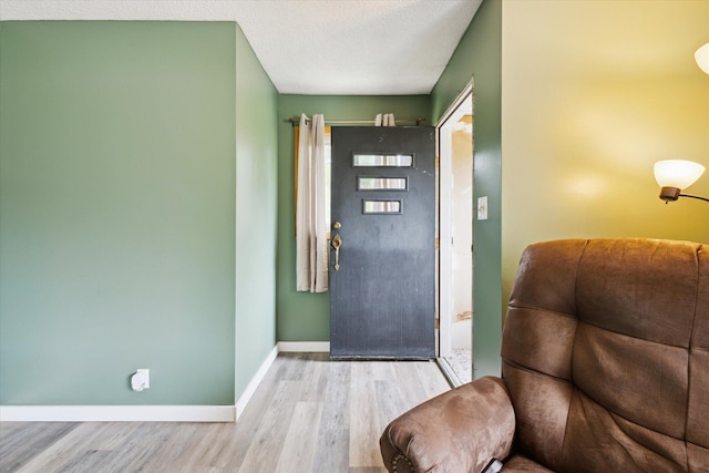foyer entrance with wood finished floors and baseboards